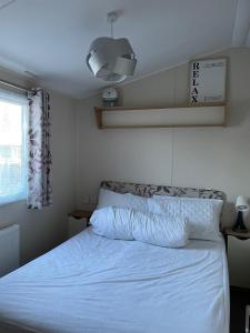 a bedroom with a white bed and a window at Luna-Rockley Park Poole in Poole