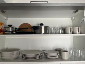 estante de cocina con platos, ollas y sartenes en Nauheim-Residenz en Bad Nauheim