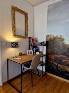 a desk with a chair in a room with a painting at Chez Valérian, gare de Chantilly in Chantilly