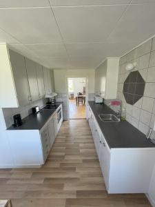 a kitchen with white cabinets and black counter tops at Vänsö in Sankt Anna