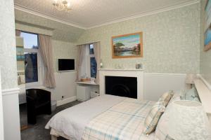 een slaapkamer met een bed en een open haard bij Dunvegan Bed & Breakfast in Dufftown