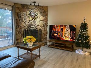 a living room with a stone fireplace and a tv at Lovely 3 bedrooms 2 bathrooms fourplex near Calgary Downtown in Calgary