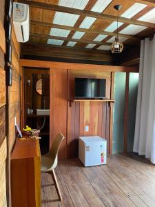 Zimmer mit einem Schreibtisch, einem Stuhl und einem TV in der Unterkunft Chalés Mãe Natureza in Vera Cruz de Itaparica
