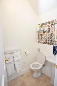 een witte badkamer met een toilet en een wastafel bij Dunvegan Bed & Breakfast in Dufftown