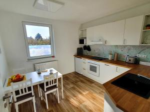 uma pequena cozinha com uma mesa e uma janela em Ferienhaus Winkler - FeWo Nordland - KEINE MONTEURE em Schwerin