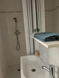 een witte badkamer met een douche en een wastafel bij Studio entre Nice et Monaco in Beaulieu-sur-Mer