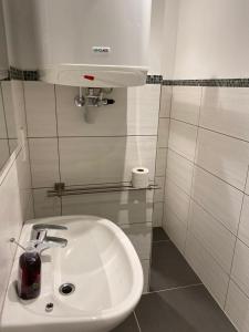 een badkamer met een witte wastafel en een licht bij Ferienwohnung DECK 3 in Cuxhaven in Cuxhaven
