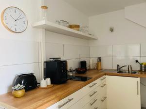 uma cozinha com um relógio na parede e um balcão em Ferienwohnung DECK 3 in Cuxhaven em Cuxhaven