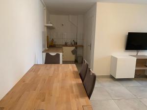 uma sala de estar com uma mesa de madeira e uma cozinha em Ferienwohnung DECK 3 in Cuxhaven em Cuxhaven