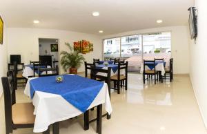 a restaurant with tables and chairs with blue table cloth at Hotel Regine's Manizales in Manizales