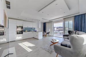 een woonkamer met een bank en een keuken bij Opal Apartments in Balatonkenese