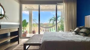 une chambre avec un lit et une grande fenêtre dans l'établissement Cozy Terrace @ Blue House, à Puerto Aventuras