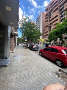 コルドバにあるVení a descubrír Nueva Córdoba, ubicación estratégica!の建物のある街路に停められた赤い車