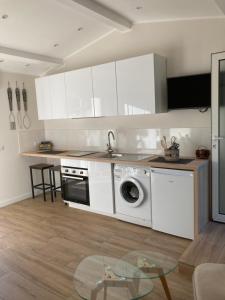 uma cozinha com armários brancos e uma máquina de lavar roupa em Studio grasse sud em Grasse