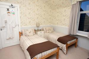 een slaapkamer met 2 bedden en een raam bij Dunvegan Bed & Breakfast in Dufftown