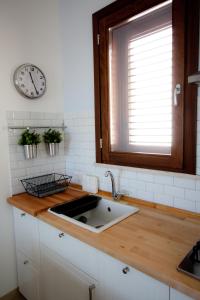 a kitchen with a sink and a clock on the wall at Casa Oltremare UnmarediBlu in San Vito lo Capo