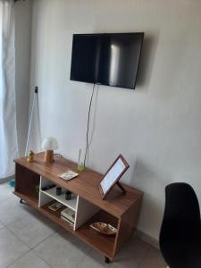 a living room with a table with a television on a wall at Precioso departamento en Maipú in Maipú