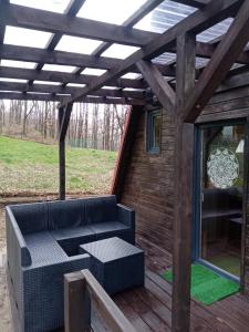 une pergola avec un canapé sur une terrasse dans l'établissement Chatka pod lasem, à Jarnołtówek