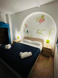 - une chambre avec un grand lit orné d'une fresque murale représentant des fleurs dans l'établissement Cartari Apartment, à Palerme