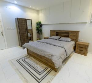 a bedroom with a large bed and a mirror at شاليهات الجوري in Al Harazat