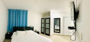 1 dormitorio con cama y cortina azul en Apartahotel Bahia Tropical II en San Andrés