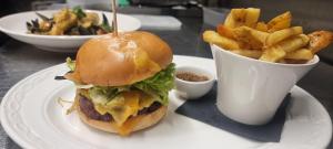 a sandwich and fries on a plate with a cup of sauce at 53 Luxury Accommodation in Maynooth