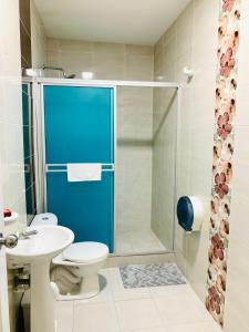 a bathroom with a toilet and a shower with a blue door at Apartahotel Bahia Tropical II in San Andrés