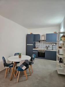 a kitchen with a table and chairs and blue cabinets at Terrazza Meraviglia in Riomaggiore