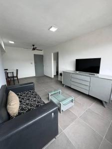 uma sala de estar com um sofá preto e uma televisão de ecrã plano em Mendoza desde lo alto em Mendoza