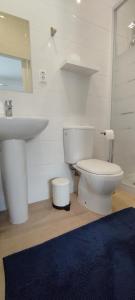 a bathroom with a white toilet and a sink at Ribeiro´s House in Gafanha da Nazaré