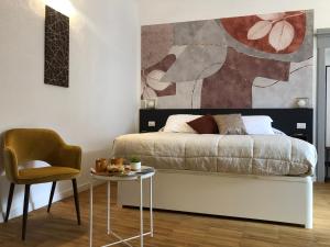 a bedroom with a bed and a table with a chair at DIMOR'A' ROOMS in Pitigliano