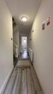 pusty pokój z korytarzem z drewnianą podłogą w obiekcie 15 min to Central London Guest Suites 22 w Londynie