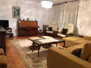 salon z pianinem, krzesłami i stołem w obiekcie Apartment TARGET w mieście Cetynia
