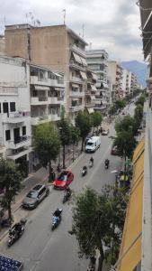ulica miejska z samochodami, motocyklami i budynkami w obiekcie Patras Stay w mieście Patras