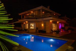 una villa con piscina di notte di Villa Palmera a Palma de Mallorca