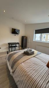 sypialnia z dużym łóżkiem i stołem w obiekcie 15 min to Central London Guest Suites 22 w Londynie
