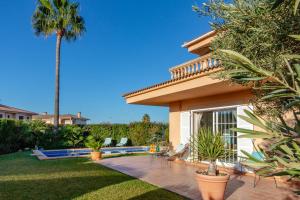 a house with a palm tree and a patio at Villa Palmera in Palma de Mallorca
