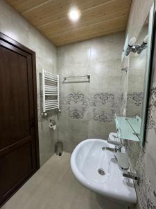 een badkamer met een wastafel en een spiegel bij guest house TMT in Sighnaghi