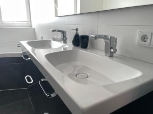 a white bathroom sink with two faucets on it at Ferienwohnung Hospitalgraben in Weimar +23 photos