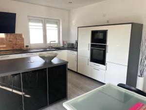 a kitchen with white cabinets and a black counter top at Ferienwohnung Hospitalgraben in Weimar