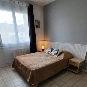 1 dormitorio con cama y ventana grande en LE PETIT SARMENTIN, en Saint-Romain-sur-Cher