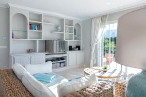 a living room with a white couch and a table at Villa Palmera in Palma de Mallorca