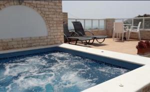 a swimming pool in a patio with two chairs at Villa Roussa in Fira