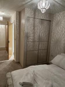 Un dormitorio con una cama grande y una lámpara de araña. en Love a staycation 2 bed apartment, en Maidenhead