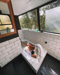 a person laying in a bath tub in a room at Ônibus Retrô - Domingos Martins/ES in Domingos Martins