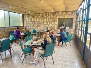 a group of people sitting at tables in a restaurant at Heritige Inn Jordan in Ad Dimnah