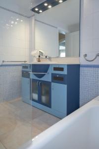 una cucina blu con lavandino e specchio di Villa Palmera a Palma de Mallorca