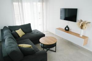 ein Wohnzimmer mit einem Sofa und einem Tisch in der Unterkunft Apartment Castellano in Kaštela