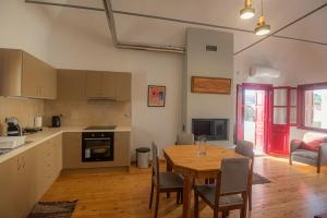a kitchen and dining room with a table and chairs at To PAPPOUDIKO CHIOS in Chios