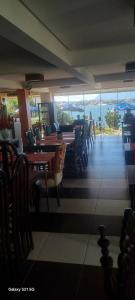 uma sala de jantar com mesas, cadeiras e janelas em Pousada do Farol Bar e Restaurante em Vila Velha